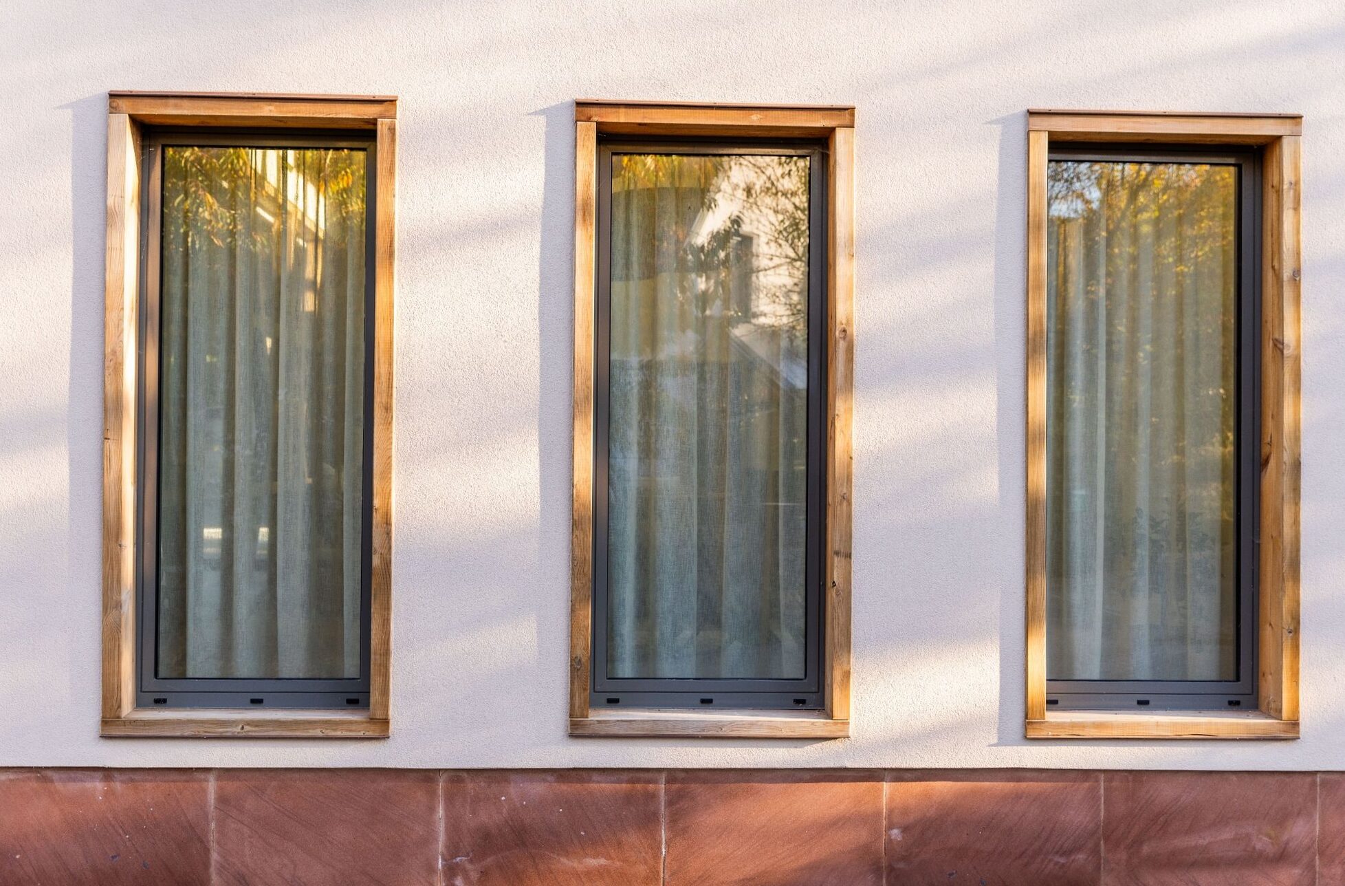 Façade de la Maison Eguisheim, fenêtres à cadres bois sur enduit clair et socle en grès, photo de l’agence VieW architecture & décoration